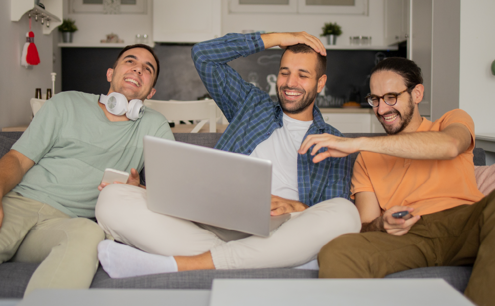 A group of friends streaming a movie and laughing whose data will be collected via Nielsen's streaming measurement solution.